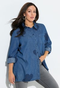 Denim blouse met een losse pasvorm, voorzien van hartvormige patronen in een donkerder blauw. Ontwerp met knoopjes aan de voorkant, borstzakje en opgerolde mouwen.