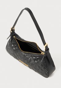 Quilted black leather handbag with a gold zipper, shoulder strap, and text logo. Features a structured shape and smooth texture.