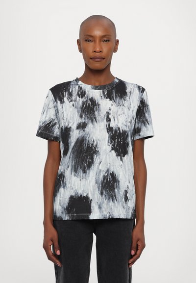 Kortærmet t-shirt i sort og hvidt abstrakt mønster med rund hals og afslappet pasform. Fremstillet af blødt, tekstureret stof.