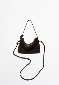 Brown suede shoulder bag with a curved shape, zip closure, and a thin black adjustable strap. Smooth texture and minimalist design.