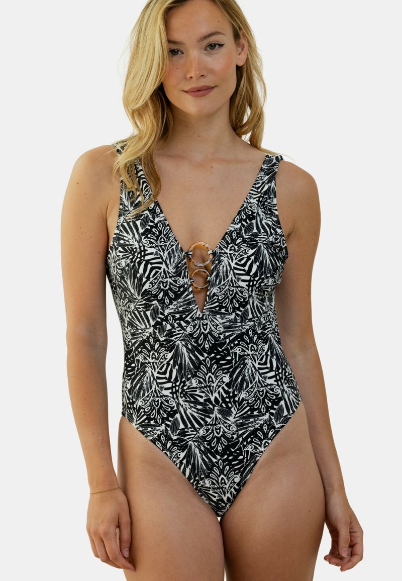 Maillot de bain une pièce noir et blanc avec un motif de feuilles, présentant un décolleté en V profond et des accents dorés en forme d'anneau à l'avant.