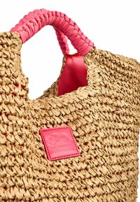 Borsa a tote in paglia intrecciata con manico intrecciato rosa, dotata di un'etichetta logata in pelle rosa embossata. Materiale testurizzato con design a apertura superiore.