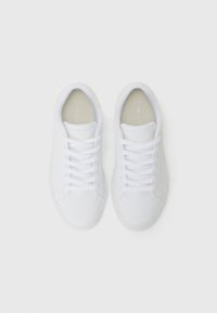 Hvide lædersneakers med en glat overflade, rund tå, flade snørebånd og et subtilt logo på tungen. Klassisk low-top design.