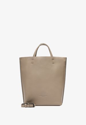 Sac fourre-tout en cuir beige avec deux poignées supérieures et une bandoulière amovible. Texture lisse et design minimaliste, mettant en avant de subtils détails de couture.