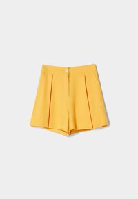 Pantalones cortos amarillos con pliegues, que cuentan con un cierre de botón y dos bolsillos laterales. Fabricados con una tela suave y con una forma limpia y estructurada.