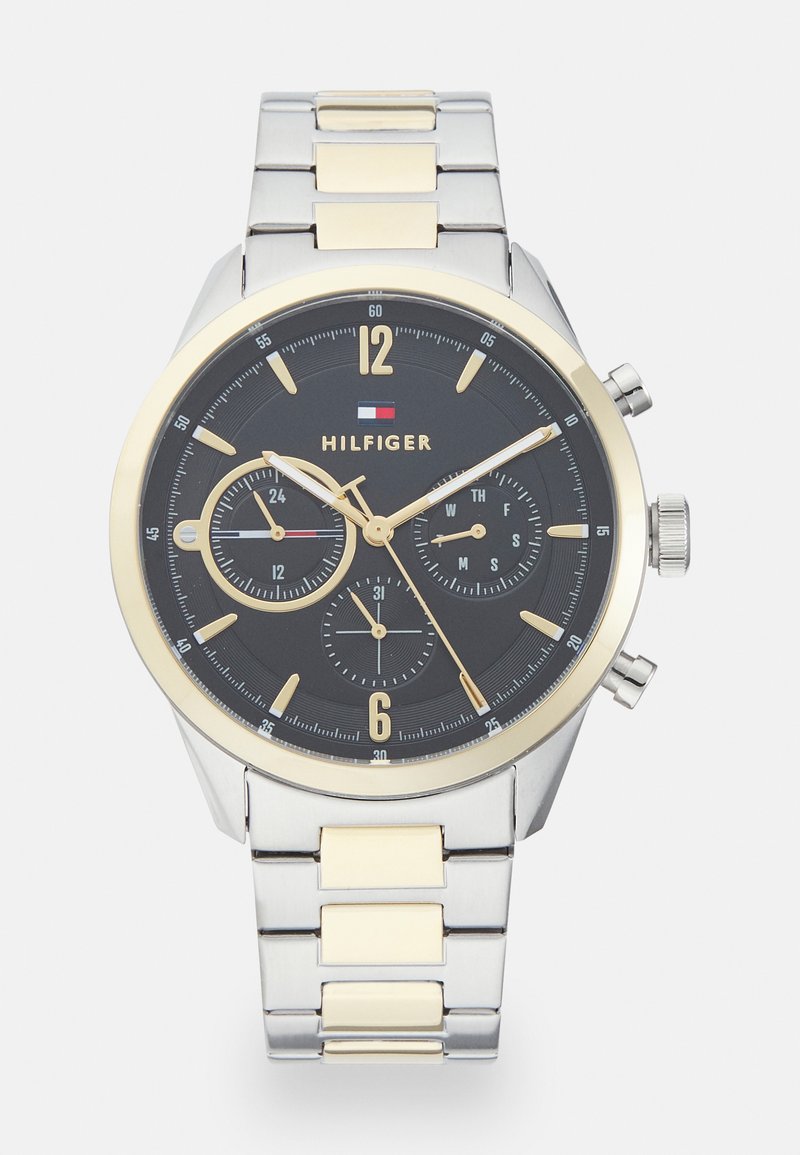 Silber- und goldfarbener Armbanduhr mit schwarzem Zifferblatt, Chronographen-Unterzifferblättern, arabischen Ziffern und einem Armband aus Edelstahl.