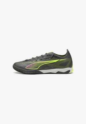 Gray athletic shoe with a sleek design, featuring lime green accents, textured mesh upper, and a patterned sole for traction.
