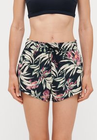 Blomstrete badetights med svart bakgrunn og tropiske plante- og blomster mønstre. Elastisk midjebånd med snortrekk.