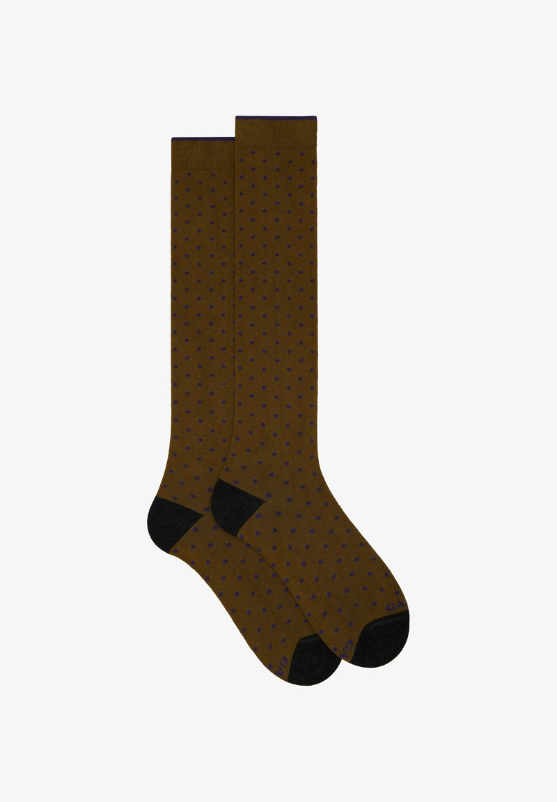 Braune Socken mit einem gepunkteten Muster in Lila. Schwarze Akzente an der Zehe und dem Bündchen. Glatte Textur, knielange Länge.