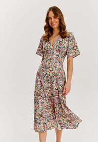 Květinové midi šaty s hlubokým výstřihem do V, krátkými rukávy a bočním rozparkem. Obsahují barevnou kombinaci růžové, žluté a zelené. Hladká látka.