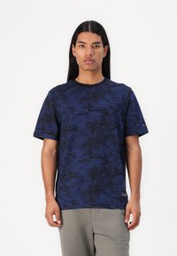 Tricou scurt de culoare bleumarin, cu un model texturat de frunze de palmier negre. Are guler rotund și un mic logo pe lateral.