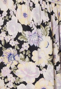 Tecido floral com grandes flores brancas, amarelas e lavanda num fundo preto; apresenta folhas verdes e pequenas flores por toda parte.