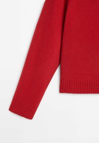 Pull rouge à manches longues en maille avec poignets et ourlet côtelés, présenté sur fond blanc.
