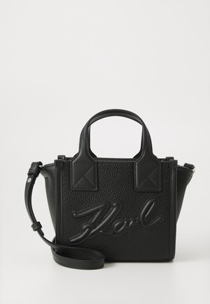 Sac à main en cuir noir texturé avec double poignée, bandoulière détachable et logo "Karl" en relief, écrit en cursive, sur le devant.