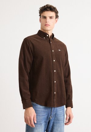 Bruine corduroy overhemd met een button-down kraag, lange mouwen en witte knopen. Bevat een geborduurd logo op de borst.