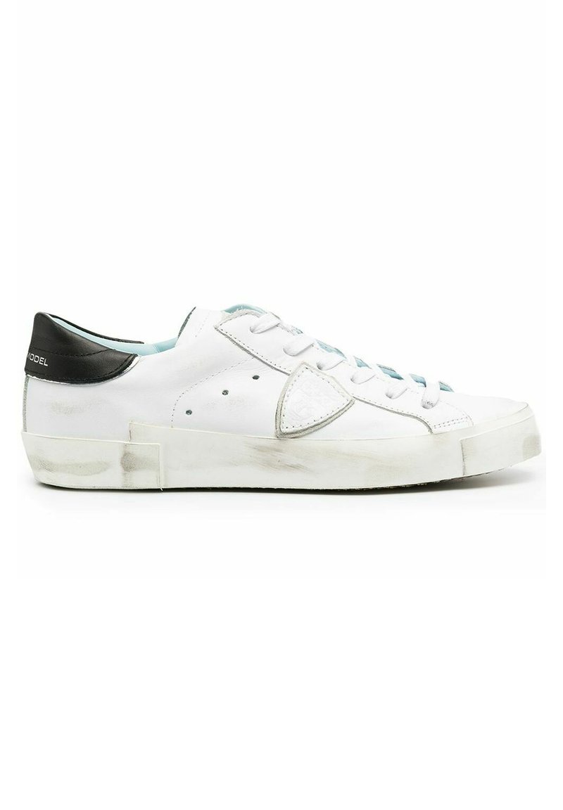 Sneaker bianca in pelle con tallone nero texturizzato e dettagli azzurri chiari. Presenta lacci bianchi, un logo sul tallone e una suola leggermente usurata.