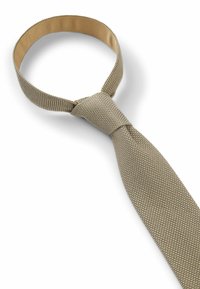 Cravatta dorata testurizzata con motivo intrecciato, caratterizzata da un nodo piatto e una banda regolabile. Il materiale ha una finitura lucida con una texture liscia.