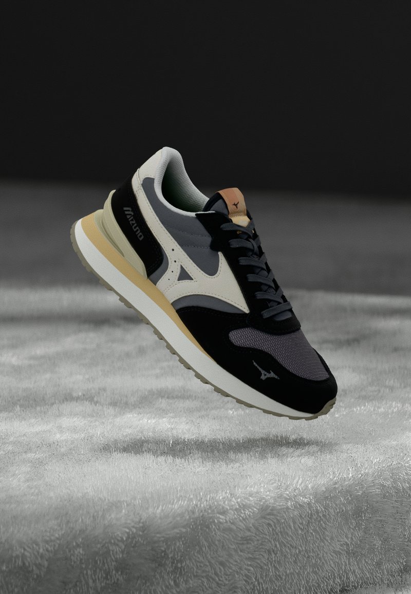 Black and grey sneaker with mesh, suede, and rubber materials. Features a cream midsole, beige accents, and contrasting logo details.