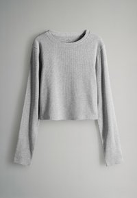 Pelēks īss, garām piedurknēm džemperis, izgatavots no ribotas auduma. Iespējas ietver apaļu kakla izgriezumu un brīvu piegriezumu ar nolaistām plecu šuvēm.