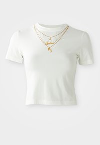 White short-sleeve cropped t-shirt with gold printed text "Jordan" and "MJ," featuring layered gold necklaces over the neckline.