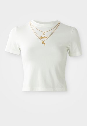 Witte cropped t-shirt met korte mouwen waarop goudkleurige tekst "Jordan" en "MJ" is gedrukt, met gelaagde gouden kettingen over de halslijn.