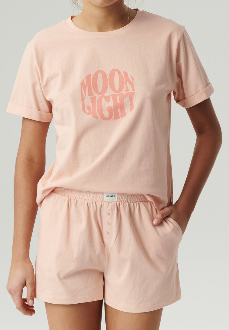 Jasnoróżowa bawełniana koszulka z krótkimi, podwiniętymi rękawami i grafiką "MOON LIGHT". W komplecie z dopasowanymi, miękkimi szortami z elastycznym pasem.