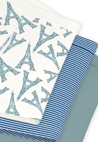 Σετ βαμβακερών κλινοσκεπασμάτων που περιλαμβάνει ένα λευκό σεντόνι με μπλε σχέδιο Πύργου του Άιφελ, μια μπλε ριγέ κάλυμμα πάπλωματος και ένα μονόχρωμο ανοιχτό μπλε σεντόνι.