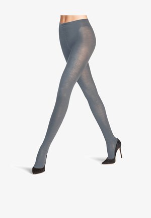 Collant grigi opachi con una superficie liscia e un delicato motivo a coste, che arrivano fino alle caviglie, indossati con scarpe nere con tacco alto.