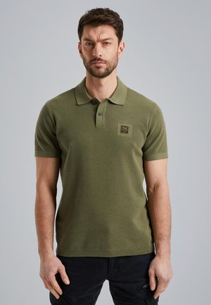 Polo olive vert avec un tissu en maille texturé, patte de boutonnage à trois boutons et un petit logo en forme de carré sur la poitrine. Manches courtes.