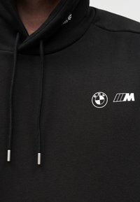Μαύρο φούτερ με κορδόνια και λευκά λογότυπα BMW και M τυπωμένα στην περιοχή του στήθους.