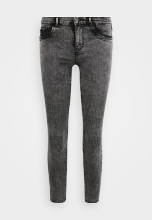 Jeans de mezclilla negra ajustados con un lavado desvanecido, cinco bolsillos, cierre de botón y sutiles marcas de desgaste en la parte frontal para añadir textura.