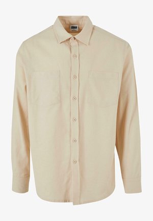 Világos bézs hosszú ujjú ing, gallérral, gombos záródással és két mellzsebbel. Simább anyagból készült, sima textúrával.