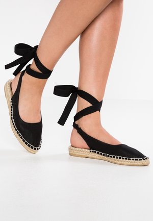 Espadrillas nere con toma in tessuto morbido, suola in giuta intrecciata e lacci alla caviglia in tessuto nero, con un design aperto sul retro.