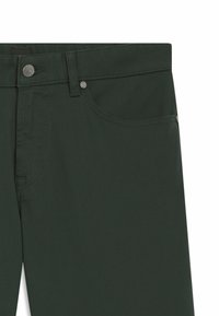 Pantaloni verde scuro realizzati in tessuto strutturato, con chiusura a bottone metallico, tasca frontale e dettagli di cucitura sottili lungo le cuciture.