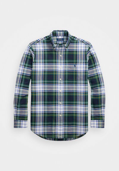 Zelena, modra in bela karirana srajca z dolgimi rokavi in gumbi, z žepom na prsih in ukrivljenim robom. Tkanina ima mehak teksturo. Polo logo na žepu.