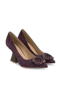 Décolleté viola in suede con punta affusolata, dettaglio anteriore decorato e tacco a blocco con motivo. Superficie texturizzata con accenti lucidi.