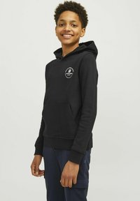 Črna kapuca s kenguru žepom in logotipom na prsih. Narejena iz mehkega, teksturiranega materiala z rebrastimi manšeti.