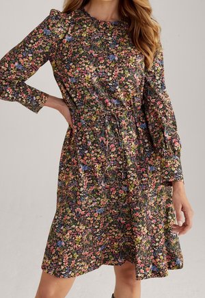 Vestido floral de manga larga, con un fondo negro y vibrantes flores en rosa, azul y amarillo. Incluye una cintura fruncida y un corte relajado.