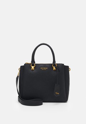 Schwarze Guess-Handtasche mit geprägtem Muster, goldfarbenen Beschlägen, zwei Griffen, einem abnehmbaren Schulterriemen und einem kleinen Markenetikett.