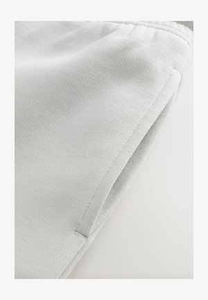 Graue Sportshorts aus strukturiertem Stoff, ausgestattet mit Seitentaschen und einem elastischen Bund. Minimalistisches Design mit einer glatten Oberfläche.