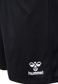 Juodos sportinės šortai pagaminti iš lengvos medžiagos, su baltu "hummel" logotipu ir lygiu tekstūru, be raštų ar akcentų.