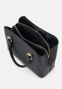 Sort læderhåndtaske med to håndtag, guld lynlås delvist åben, og et rummeligt interiør med stofforing og interne rum.
