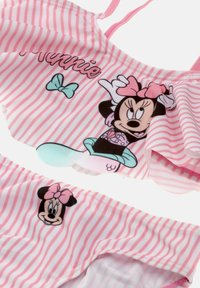 Vaatekappale vaaleanpunaisista ja valkoisista raidoista koostuvista kahdesta osasta, jossa on Minnie Hiiri ja sinisiä nauhoja, sekä rypytetty toppi ja siihen sopivat alaosat.