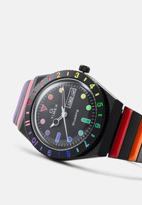 Black quartz watch with vibrant multi-colored band. Notable features include geometric hour markers and a date display.