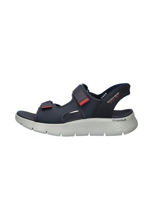 Zwarte sportieve sandaal met twee verstelbare bandjes, gewatteerde witte zool en open hiel, gelabeld Skechers Go Walk Slip-Ins.