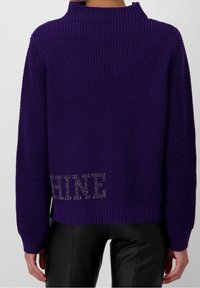 Maglione viola lavorato a maglia con collo alto, tessuto strutturato e dettaglio a ritaglio con la parola "SHINE" all'orlo.