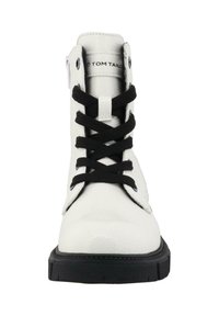 Hvide læderankelstøvler med sorte snørebånd, en tekstureret overflade, rund tå, sort sål og logo på tungen, designet til afslappet brug.