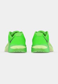 Zöld sportcipők texturált hálós felsőrésszel, párnázott gumírozott nyakkal és sarokkal, alacsony profilú kialakítással és rugalmas barázdákkal ellátott gumi talppal.
