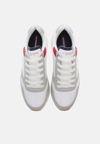 Scarpe sportive bianche e grigie con accenti in mesh e pelle. Spesse stringhe bianche e dettaglio rosso sul tallone. Logo "U.S. Polo Assn." sulla linguetta.