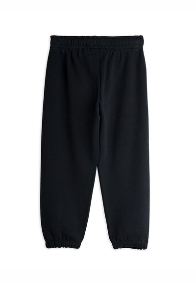Schwarze Jogginghose mit elastischem Bund und Bündchen an den Knöcheln, flach auf einem weißen Hintergrund ausgelegt.